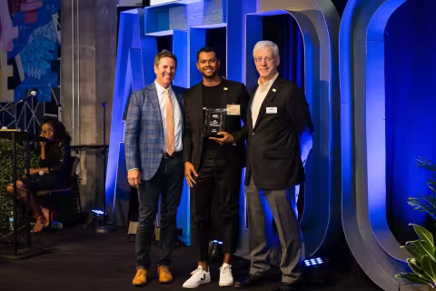 Tyler Mulkey of PurpleCloud Technologies standing on stage at the ATDC graduation with his award beside ATDC director, John Avery and ATDC Lead Entrepreneur In Residence (EIR), Chris Nedza.