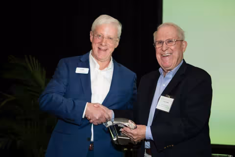 John Avery, ATDC Director and Wayne Hodges, ATDC Founder shaking hands as Wayne accepts his award into the ATDC Hall of Fame.