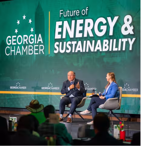 Two people talking on stage at a conference.